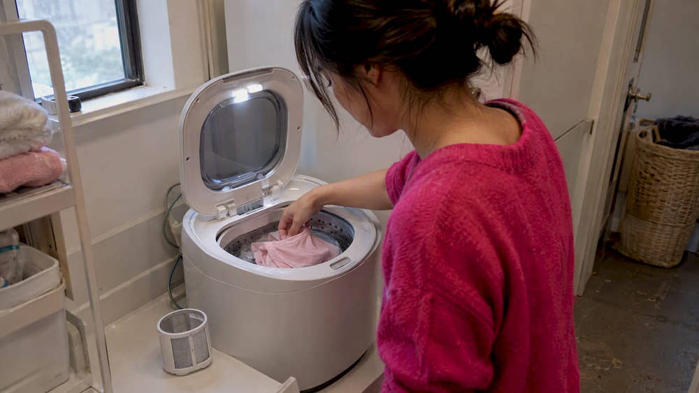 Mini washer filter beside delicate garment