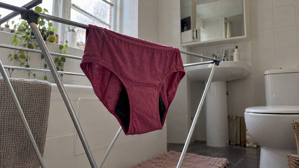 Period underwear drying on an indoor rack